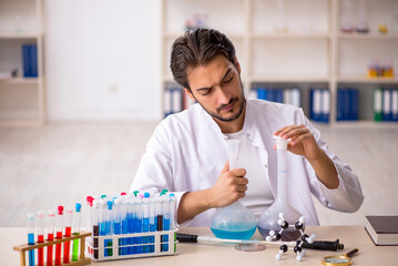 Young male chemist working at the lab