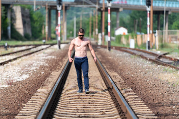 Portrait of Muscular Man Standing Outdoors at Railroad