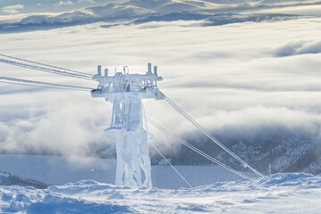 frozen funicular support poles over clouds. ski lift technology in winter, ski resort, mountain...