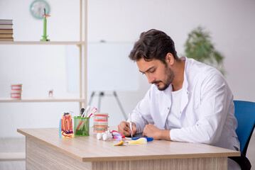 Young male dentist working in the clinic