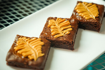 Homemade pieces of brownies on white dish.