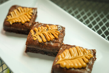Homemade pieces of brownies on white dish.