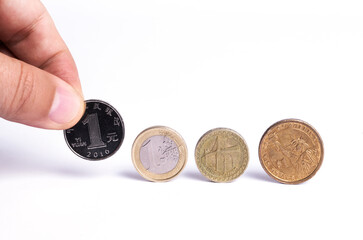 Fototapeta premium Coins on the edge of one yuan, one euro, one pound, one dollar on a white background. A composition symbolizing the importance of the leading currencies in the global economic arena.