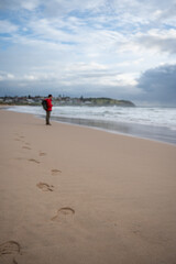 walking on the beach footprints and unrecognizable man on the beach 