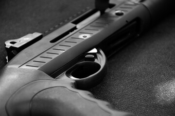 Closeup view of black shotgun which is on the black leather background, concept for shooting sport,...