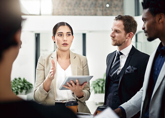 Are you understanding me. Cropped shot of a group of businesspeople looking at a tablet in the office.