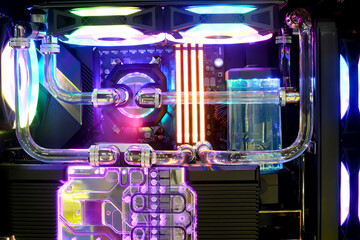 Close-up and inside on Hi-performance custom computer desktop with water block cooling installed on CPU processor with multicolored LED neon light show on working