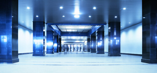 People moving in an underground passage. Tint blue