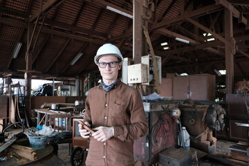 Worker in a construction helmet in a warehouse or workshop