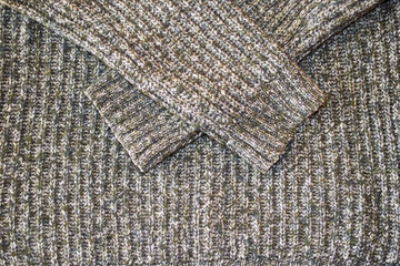 Texture of knitted wool sweater with sleeves close-up, horizontal format