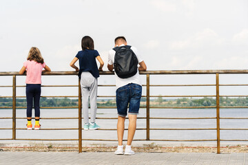 Father with children walks on the embankment. A man with his daughters admires the view of the bay...