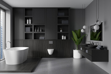 Grey bathroom interior with bathtub, toilet, sink with window