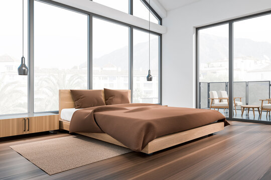 Corner view on bright bedroom interior with bed, panoramic window