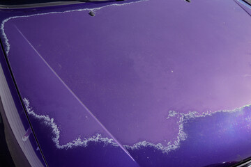 purple car hood with worn blue paint faded by the sun and age
