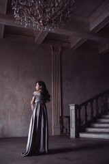 Young woman in beautiful long dress indoors