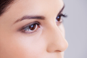 Shes a sight for sore eyes. Studio shot of a beautiful brunette woman against a gray background.