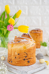 Fototapeta na wymiar Easter composition. Traditional Ukrainian Easter cake - Cruffin, Kraffin or Kulich with chocolate and candied fruits on a white wooden background. Paska Easter Bread. Copy space