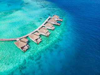 Overwater villas on tropical atoll island for holidays vacation travel and honeymoon. Luxury resort...