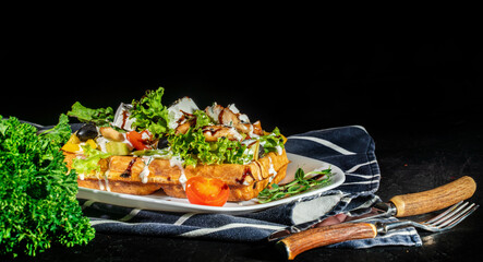Belgian waffles with feta, olives and chicken on dark background