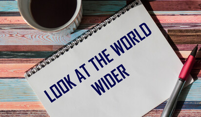 Motivational phrase on notepad Look at the world wider
