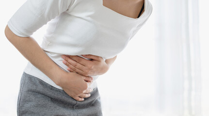 Young woman put her hand on her stomach because she had a very bad stomachache. menstrual pain,...