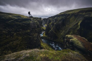 Solo hiker on a cliff watching a canyon in solitude