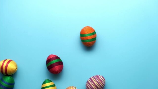 Colorful easter egg made from threads isolated on blue background. Easter concept.