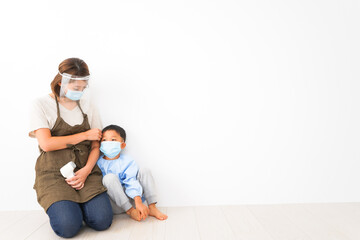 幼児の体温測定をする保育士