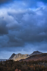 Fototapeta premium Majestic landscape image of stunning Autumn sunset light across Langdale Pikes looking from Holme Fell in Lake District