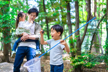 虫採りをするお父さんと子どもたち