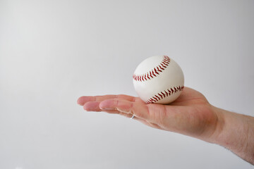 Baseball ball in the hands of a man. Baseball Match Day. Regular season games. Baseball league, team competition and championship. Baseball bat and ball. Sport party in United States. Professional