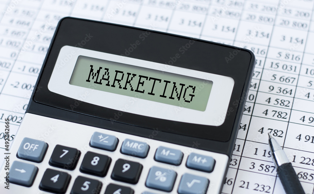Poster text marketing on the calculator screen on the background of reports on the table
