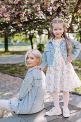 Sakura blossomed. Young mother with her child have fun in the park near the sakura. cherry trees blossom (Uzhhorod City, Ukraine)