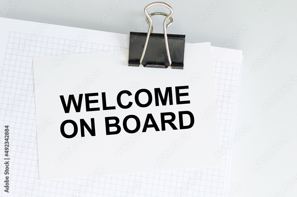 Aufkleber welcome on board text on the card on the clip on the notepad on the table