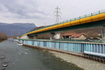 Fototapeta na wymiar La rivière Romanche avec la route Napoléon en arrière plan, ville de Champ sur Drac, département de l'Isère, France