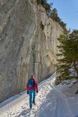 woman hiking in the snowy mountain landscape of the Alpstein mountain range near Appenzell, Switzerland