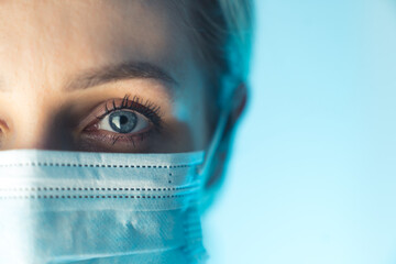 Close up portrait photo. Eye of young female doctor. Protection against contagious disease through...