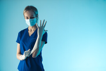 Young caucasian woman doctor putting on a white sterile glove, preparing herself for surgery....
