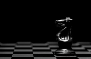 Close up of Chess pieces on a reflective mirror board surface with black background