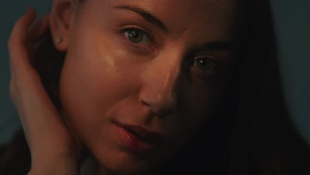 Sensual woman. Feminine beauty. Female tenderness. Seductive touch. Mysterious gentle pretty young teasing lady fondly sliding fingers against soft smooth skin in dark shadows.