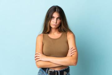 Obraz premium Young caucasian woman isolated on blue background with unhappy expression