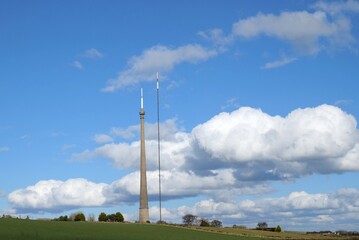 Tall transmitter masts white clouds in blue sky