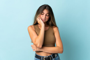Young caucasian woman isolated on blue background with toothache