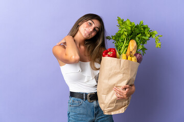 Young woman holding a grocery shopping bag laughing