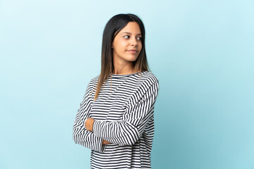 Caucasian girl isolated on blue background keeping the arms crossed