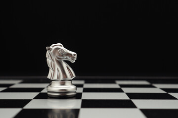Chess piece on board game planning and competition on black background