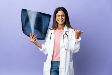 Young doctor woman holding a radiography pointing to the side to present a product