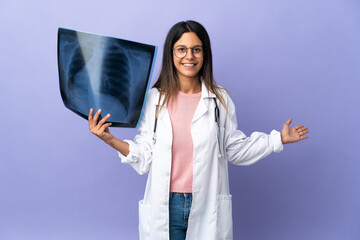 Young doctor woman holding a radiography extending hands to the side for inviting to come