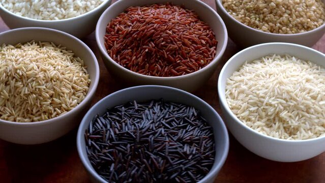 Rice of different colors and varieties. Assortment of rice grains, table spin.