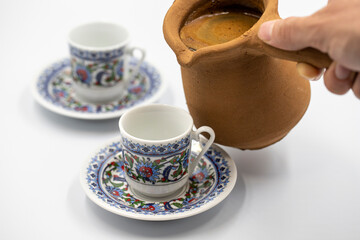 Turkish coffee in a clay pot on a white background. Traditional Turkish cuisine flavor. close up